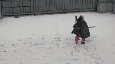 Hafif giysiler içinde dans eden Asyalı kadın kar yağışı sırasında özgürlüğün canlılığının tadını çıkarıyor.