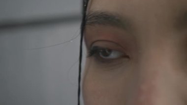 Islak kar yağışı sırasında sevimli Asyalı kadın gözleri, yakın plan.