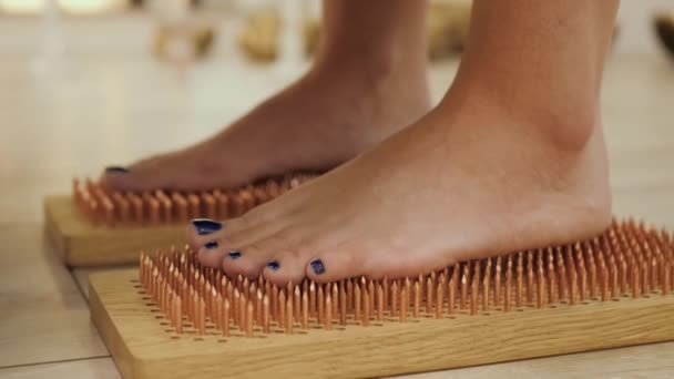 ヨガネイルボードの上に立っている裸足の女性 閉じます 爪で立っている女性の足 サドーボード — ストック動画