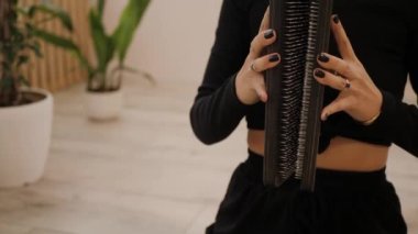 Kadın sadhu 'nun tahtaya çivilenmesi için tahta hazırlıyor. Elinde yoga ekipmanları olan bir kadın siyah bir tırnağın üzerinde durmak üzere.