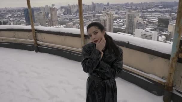 Asiatin Die Vor Dem Hintergrund Eines Schneebedeckten Daches Die Kamera — Stockvideo