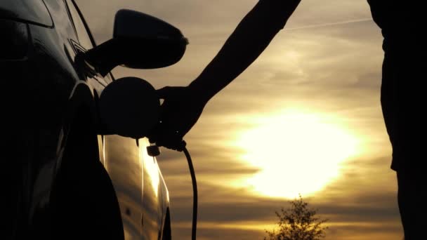 Erkek Tip Güç Bağlantısını Arabasından Ayırır Günbatımı Arka Plandadır Tanımlanamayan — Stok video