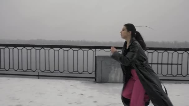 軽い服を着たアジアの若い女性は 活力と自由を運びます 雪に覆われたエンバンク サイドビューの背景に女性 — ストック動画