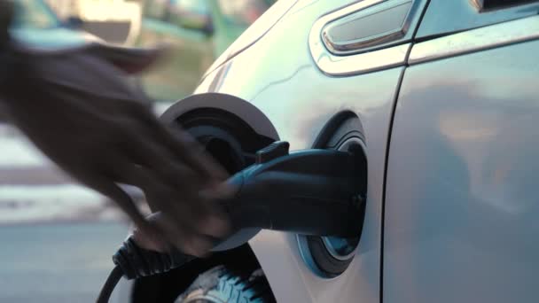 Afrikanische Männliche Hand Zieht Stromstecker Aus Elektroauto Der Nähe Der — Stockvideo