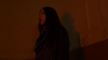 Asyalı kadın kırmızı ışıkta şarkı söylüyor. Moda insanı, duvarın yanında, yüzeysel bir odak. Güzel, seksi genç bir kadın. Şehir tarzı