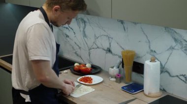 Modern mutfakta, yetenekli şef soğan doğrama ve lezzetli bir yemek hazırlama uzmanlığını sergiliyor, taze malzemelerin duyulara zevk veren lezzetli yemekler için önemini vurguluyor.