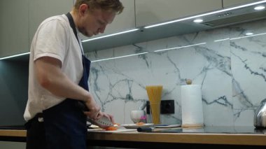 Modern bir mutfakta, yetenekli bir aşçı mutfak tezgahında taze malzemeler doğrar, sezonluk ürünlerle mutfak tekniklerini harmanlayarak duyulara hitap eden çeşitli lezzetli gurme yemekleri yapar.