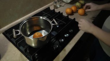 Tutkulu bir birey taze portakalları hazırlar ve onları düzenli bir fırının üzerine koyar. Organize mutfak, sevgi ve ilgi ile nefis ev yemekleri pişirmek ve her yemeği özel yapmak için idealdir.