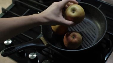 Taze, canlı elmaları fırının tepsisine koyma işlemi. Bu renkli elmalar aromayla dolup taşıyor, yemek yapmaya ya da cazip bir sunuma hazır.