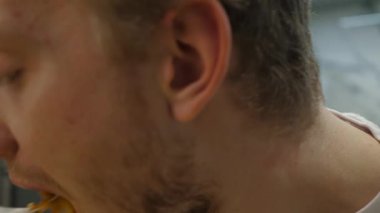 Makarna yiyen genç adam, yakın plan.