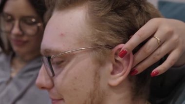 Sıcaklıkla dolu huzurlu bir anda, bir kişi nazikçe bir diğerine masaj yapar ve iletişimi teşvik eder. Bu, basit jestlerin önemini ve kişisel bakım ve yetiştirmenin önemini vurgular.