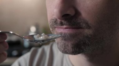 Bir adamın kaşıkla yemekten zevk aldığı yakın plan çekimleri. Duygularını ve tatma sevincini yakalıyor. Aşçılık veya yemek tutkusunu çağrıştıran yaşam tarzı projeleri için mükemmel hale getiriyor.