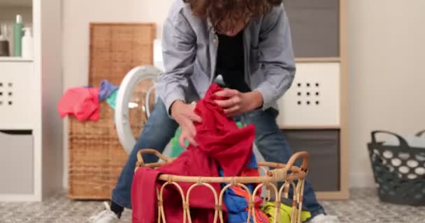 快乐的因果少年把脏衣服丢进洗衣机里 就像一个球 阿勇在洗衣房把衣服扔进洗衣机里玩得很开心 — 图库视频影像