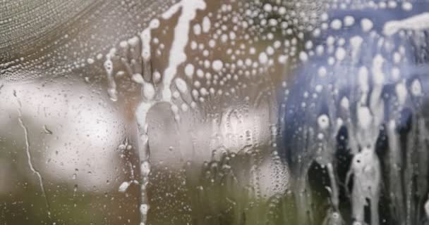 窗户清洁剂用泡沫和拉力擦拭窗户 — 图库视频影像