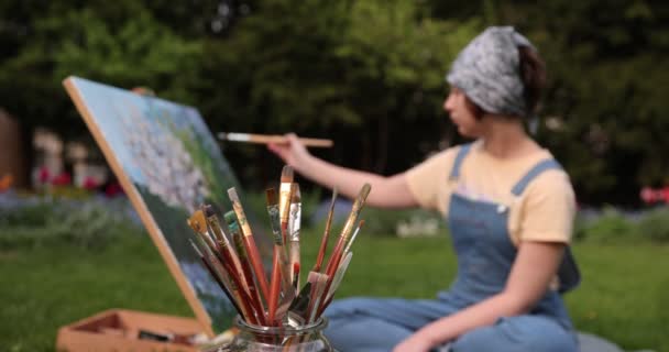 庭のアートスタジオ 油絵だ イーゼルのキャンバス 異なるサイズの汚れたブラシのセット 山水画 — ストック動画