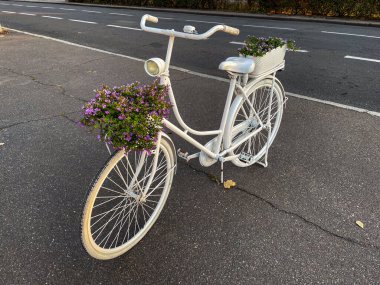Sokakta mor çiçekli beyaz klasik bisiklet