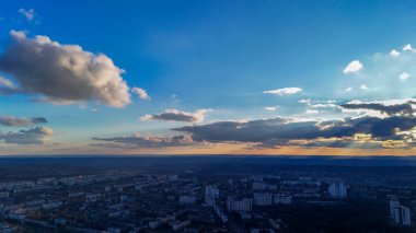 Gün batımında şehrin hava manzarası. Güneş ışınları ve dramatik bulutlar.