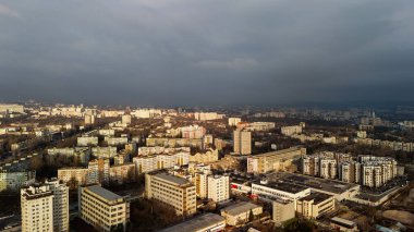 Güneş ışığı ve kara fırtına bulutlarıyla dolu şehir manzarası