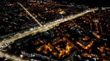 Aydınlatılmış yolların ve şehir siluetinin insansız hava aracı gece görüntüleri.