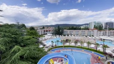 Güneşli bir günde yüzme havuzları ve su kaydıraklarıyla lüks bir tatil köyü.