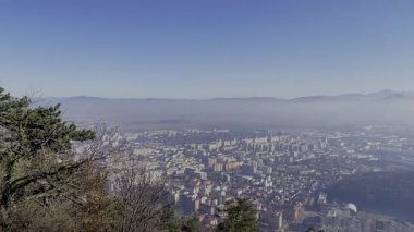 Sabahları sisli dağlarla çevrili bir şehrin havadan görünüşü.