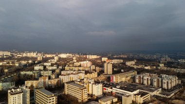 Güneş ışığı ve fırtına bulutlarıyla dramatik şehir manzarası