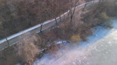 Donmuş gölün havadan görünüşü. İnsanlar kış parkında buzda yürüyor.