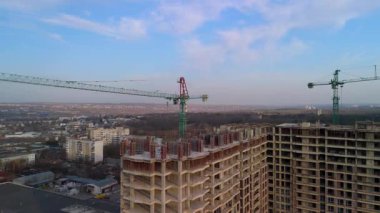 Vinçleri ve tamamlanmamış binaları olan yüksek katlı bir şantiye.