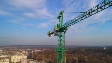 Şehir manzarasının üzerinde santral kabini olan kule vinç