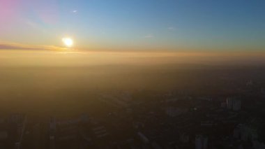 Gün batımında altın sisle şehrin havadan görünüşü