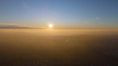 Şehrin üzerinde altın sisli havadan gün batımı manzarası