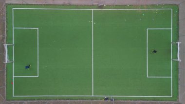 Futbol sahasındaki iki oyuncunun yukarıdan aşağıya görüntüsü