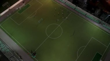 Aydınlatılmış sahada gece futbolu eğitiminin havadan görüntüsü