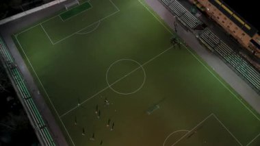 Gece futbol antrenmanının yapay alan üzerindeki hava aracı görüntüsü