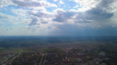 Bulutları delip geçen çarpıcı güneş ışınlarıyla dolu bir şehir manzarası.