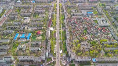 Konut binaları ve bahar yeşilliği olan şehir caddesinin yukarıdan aşağıya bakan manzarası