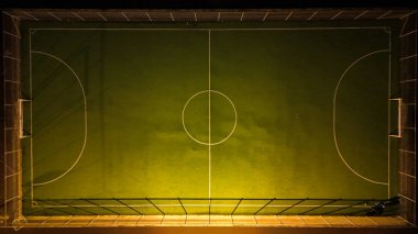Geceleri aydınlatılmış futbol sahasının yukarıdan aşağıya doğru görüntüsü
