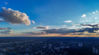 Gün batımında hava manzarası ve bulutlarda parlayan güneş ışınları.