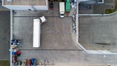 Yükleme rıhtımının kamyon ve paletlerle dolu havadan aşağı görüntüsü