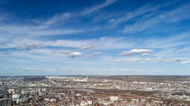 Mavi gökyüzü altında konut ve sanayi bölgeleri bulunan havadan panoramik şehir manzarası