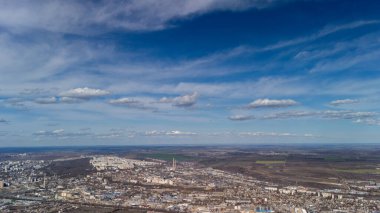 Endüstriyel yerleşim alanları ve mavi bulutlu gökyüzünün altındaki alanlar geniş panoramik şehir manzarası
