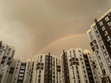 Yağmurdan sonra gökkuşağı modern yerleşim binalarının üzerinde