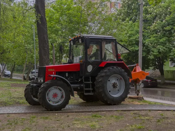 Islak zemine iliştirilmiş kırmızı traktör.