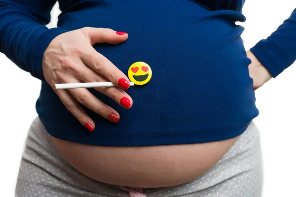 在白色摄影棚背景下 拿着香烟和心眼的孕妇在腹部的特写 — 图库照片