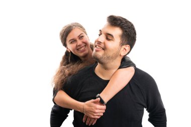 Cute girlfriend hugging adult boyfriend from behind in casual autumn attire smiling as loving male and female couple romantic concept isolated on white background