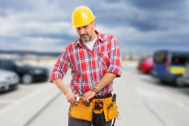 Worker man grabbing wrench from his tools pouch as working day concept