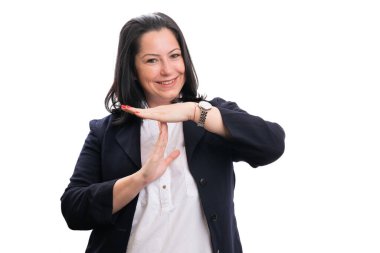 Adult businesswoman smiling with friendly expression in formalwear making pause time out gesture using hands isolated on white background