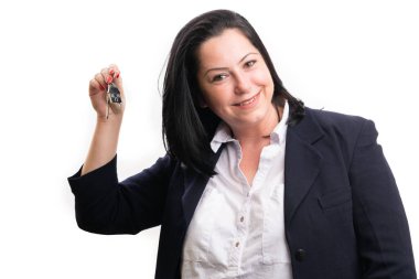 Formalite kıyafetli yetişkin kadın emlakçı. Beyaz arka planda izole edilmiş iş konsepti olarak ev anahtarlarını sunan arkadaşça bir ifadeyle gülümsüyor.