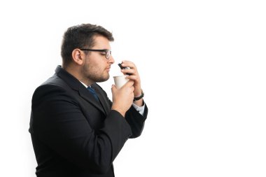 Kurumsal ofis kıyafetleri içindeki erkek girişimci sıcak kahve kokan beyaz stüdyo arka planında izole edilmiş alışkanlık olarak boş telif alanı olan kağıt bardaktan çıkmak için.