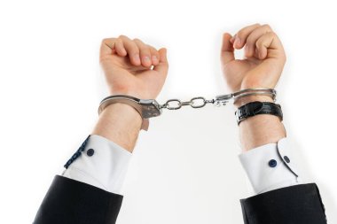 Yetişkin adam iş dünyasının profesyonel yöneticisinin, beyaz stüdyo arka planında izole edilmiş yasa dışı bir kavram olarak tutuklanmış elleri kelepçeli halde görüntüsü.